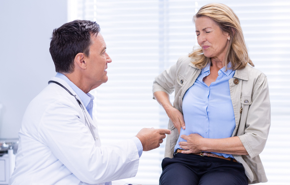A woman with ingestion pain discussing medical help with a gastroenterologist, Queensland Gastroenterology